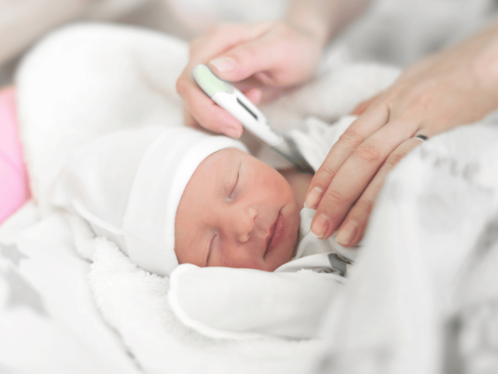 Mãe verificando a temperatura do bebê recém-nascido. Como saber se o bebê está com frio.