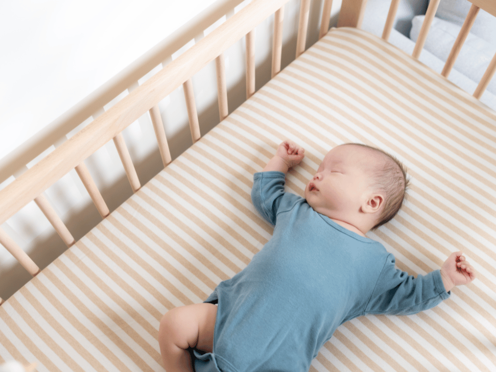 o que não comprar para o enxoval do bebê- Bebê dormindo em berço sem itens desnecessários.