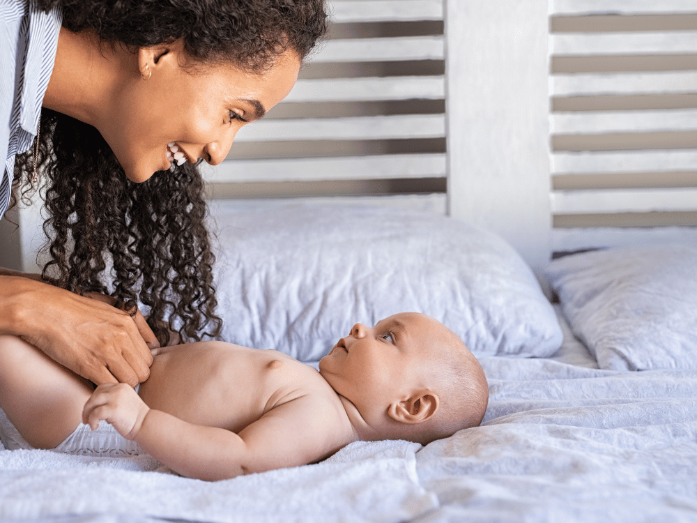 Melhores pomadas para assadura de bebê. Mãe trocando fralda do bebê.